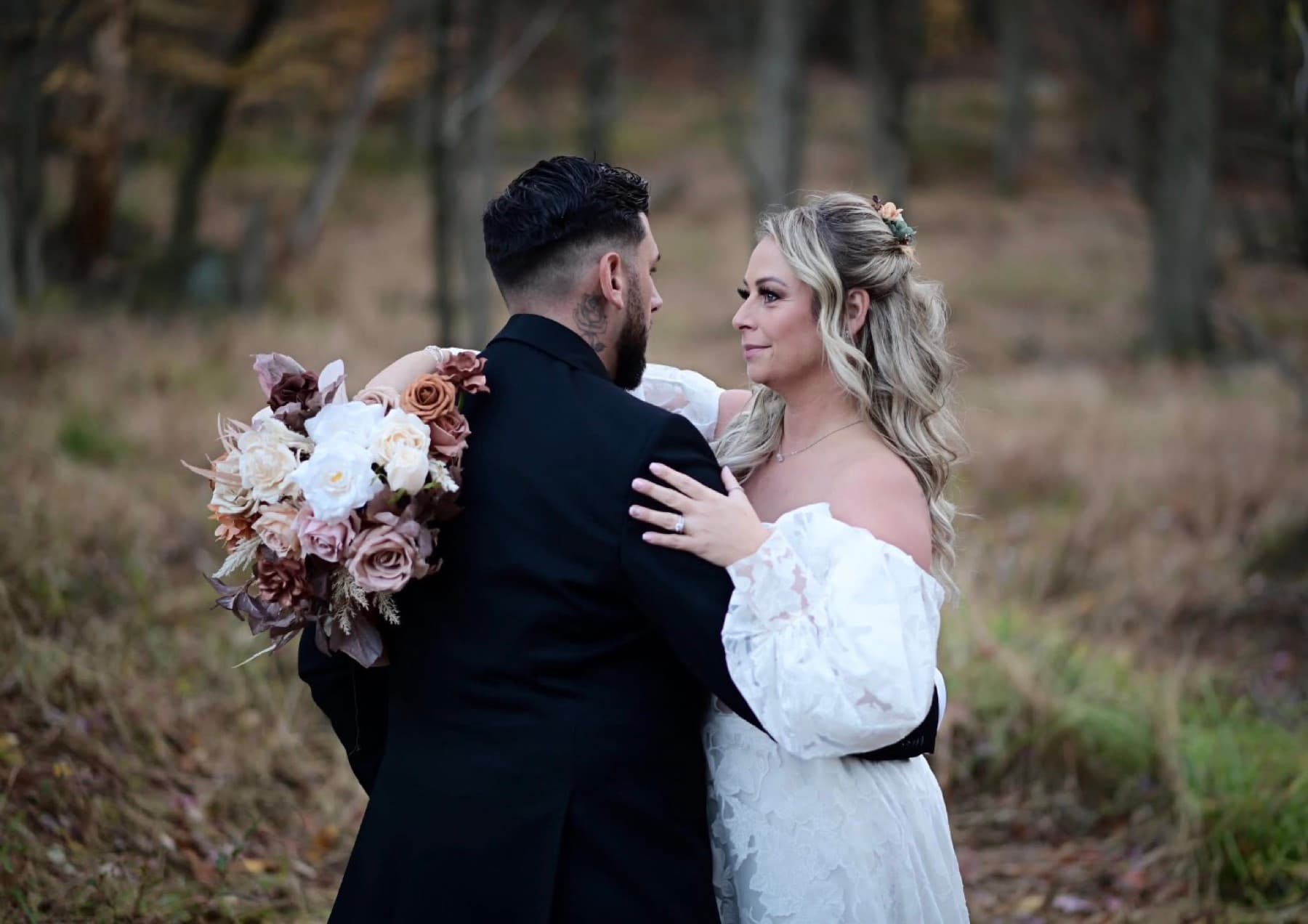 Bride and groom embracing in a field