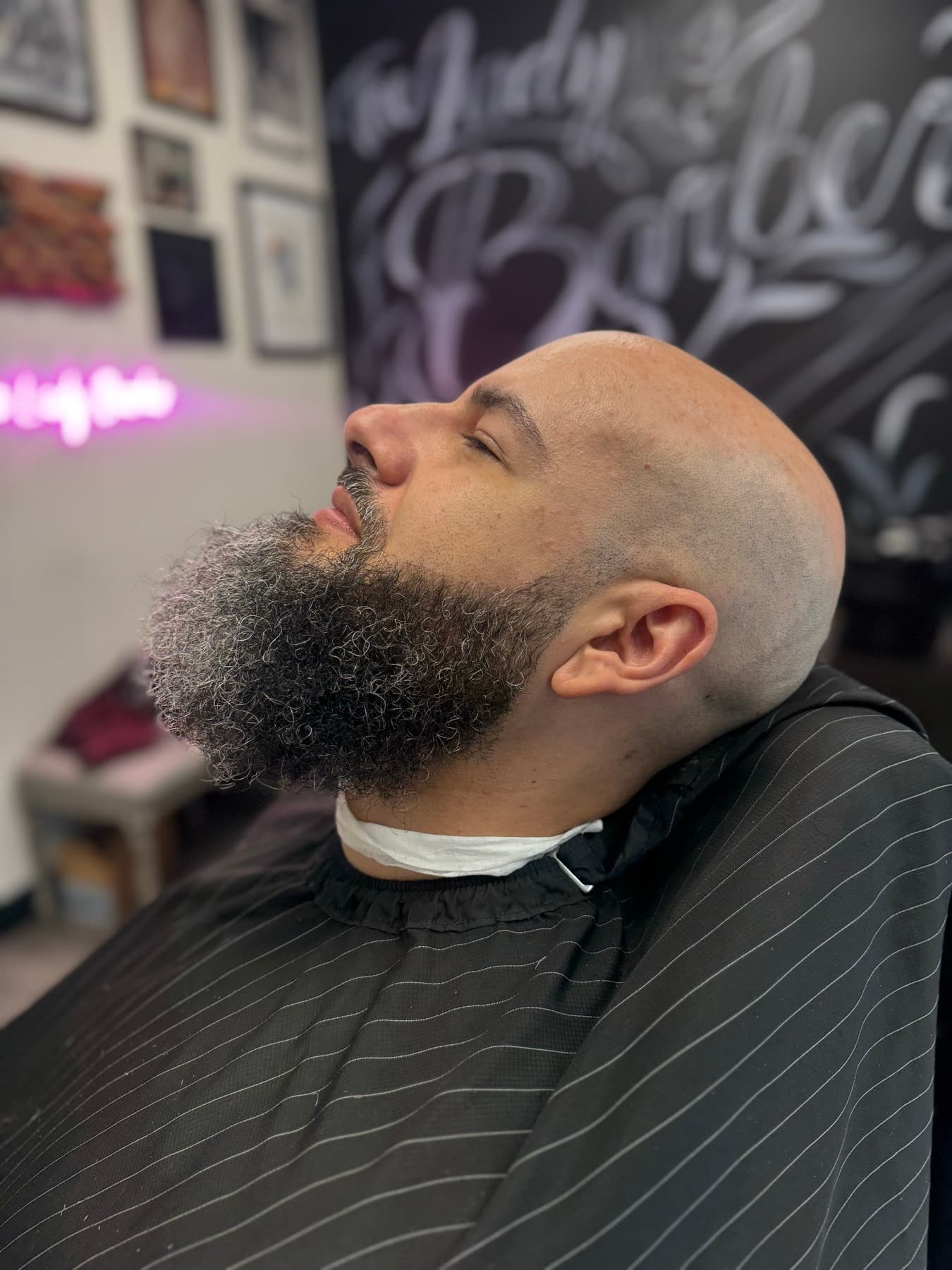 Shaved head with a large sculpted beard
