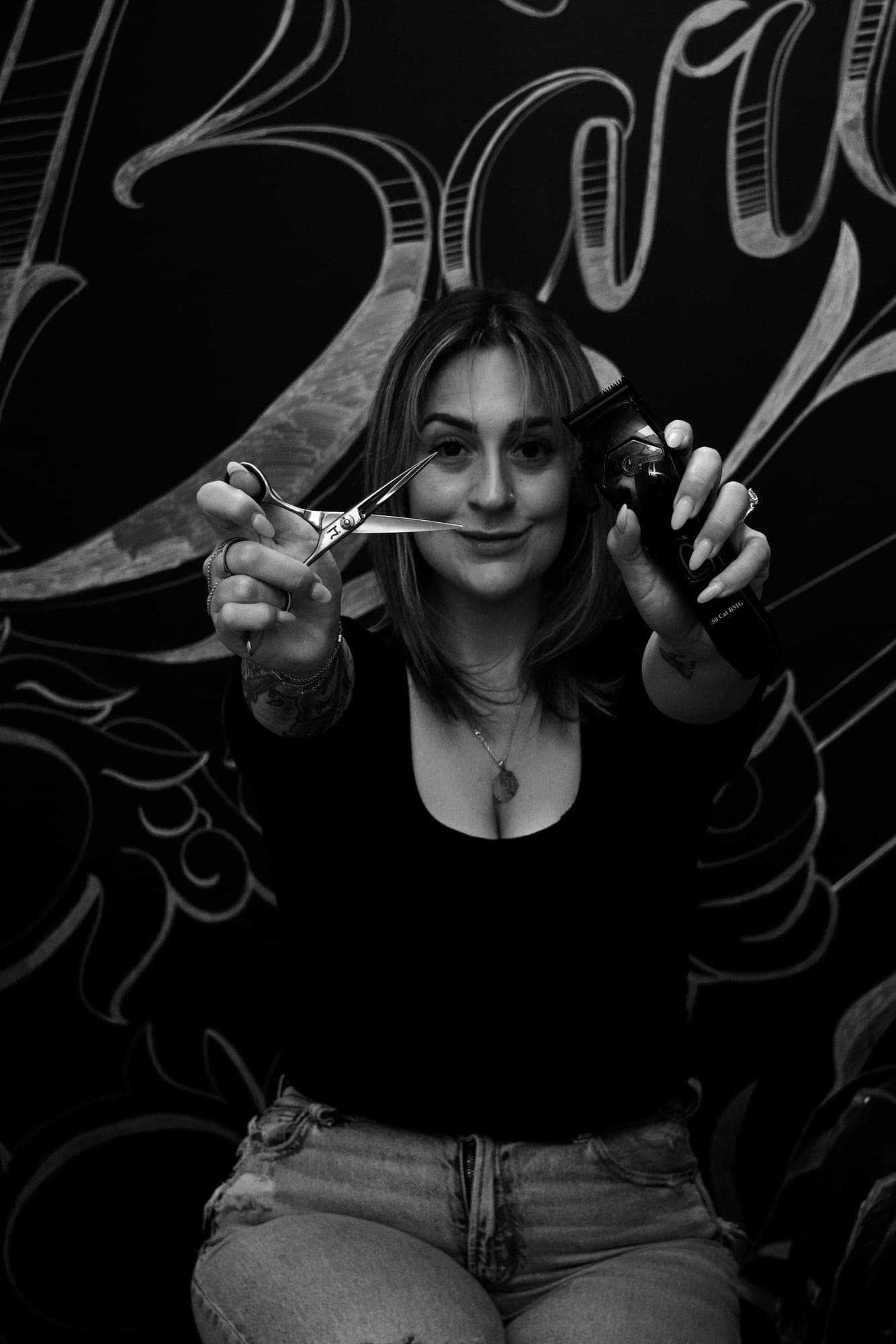Black and white photo of Jenna holding her shears and clippers